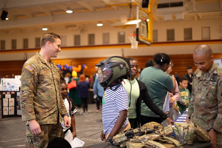 Elementary school student tries on electronic helmet.